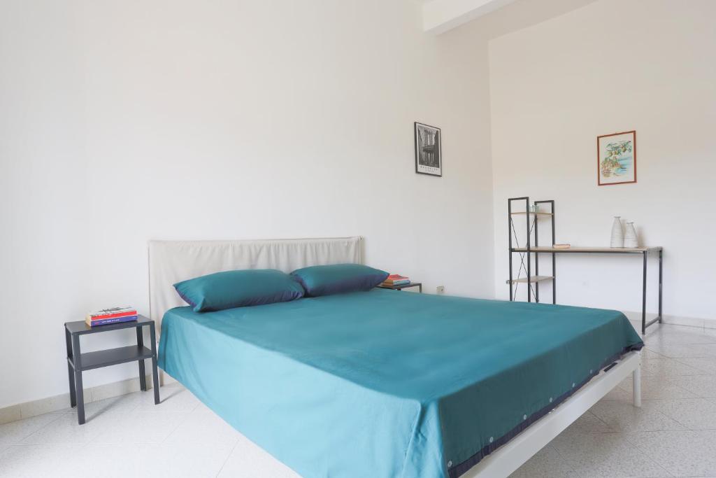 a bedroom with a bed with a blue comforter at Bright Apartment near the sea with parking in Salerno