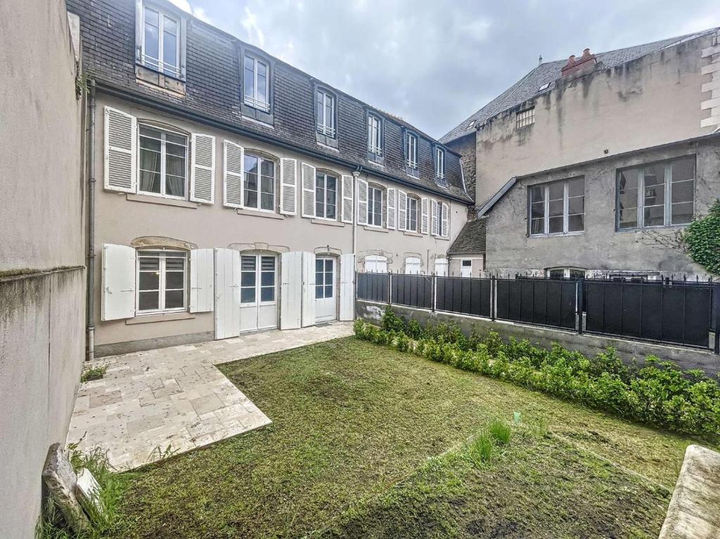 een lege werf voor twee gebouwen bij Maison de maître plein centre in Montluçon