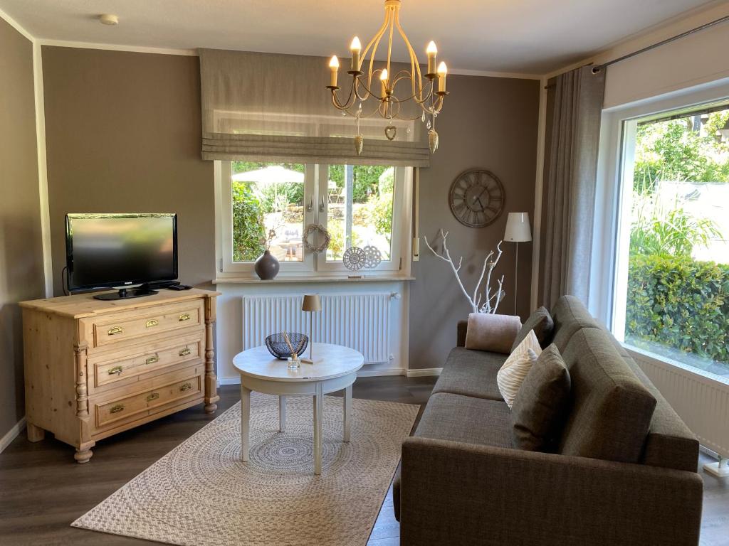 a living room with a couch and a tv and a table at Weinburg -Das Ferienhaus in Cochem