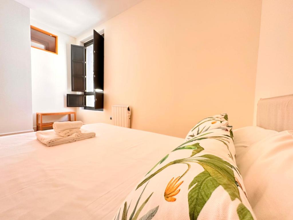 ein Schlafzimmer mit einem Bett mit einer Decke darauf in der Unterkunft Penthouse near cathedral private rooftop Private Parking in Sevilla