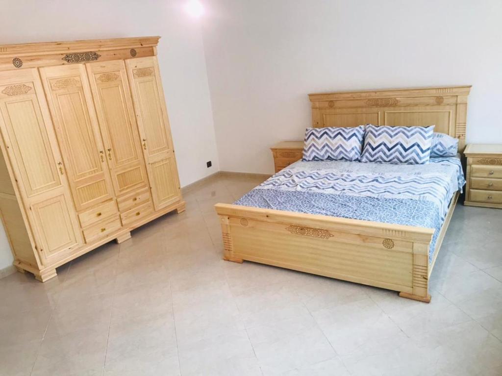 - une chambre avec un lit en bois et des placards en bois dans l'établissement Un coin de tranquillité en plein cœur de l'action, à Al Hoceïma