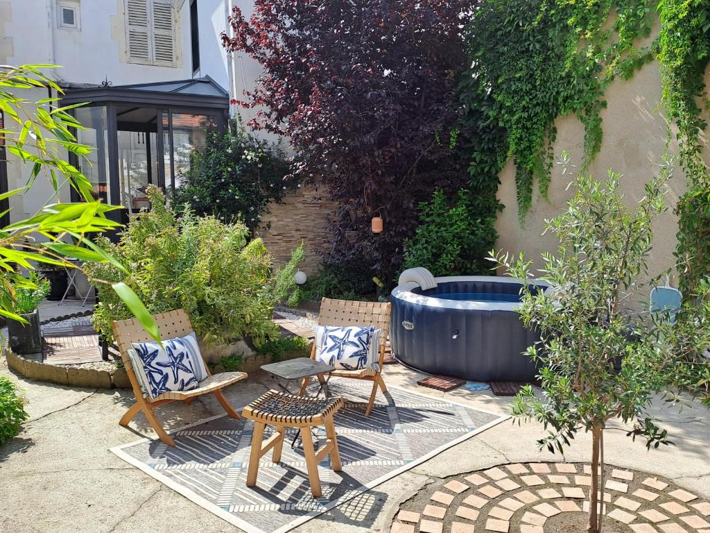 d'un jardin avec des chaises et une grande baignoire. dans l'établissement Chambre d'hôte des Thermes, à Vichy