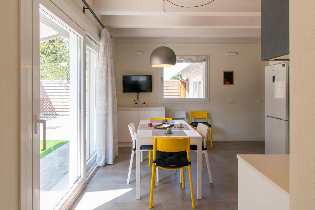 uma cozinha e sala de jantar com mesa e cadeiras amarelas em Vicino alla Villa Palladiana La Rotonda! Duplex Apartment em Vicenza