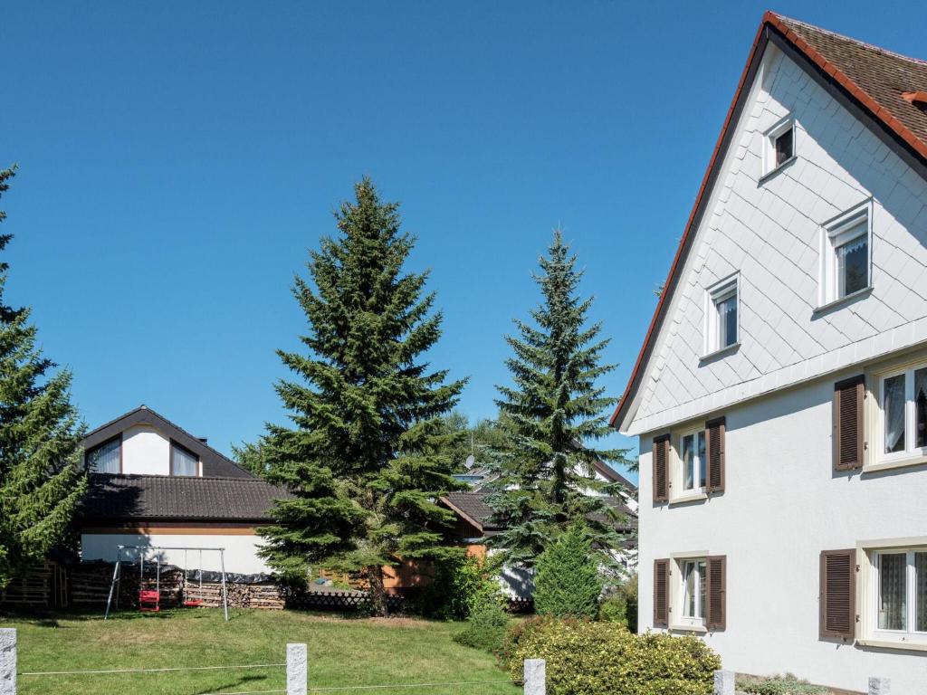 a house with two pine trees in the yard at Cozy Apartment in Schwenningen with Garden in Villingen-Schwenningen