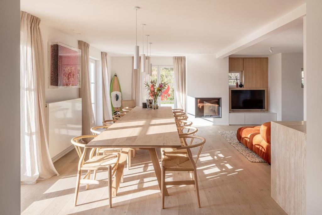 a long dining room with a long table and chairs at Maison Ensor - Lux Living in De Panne