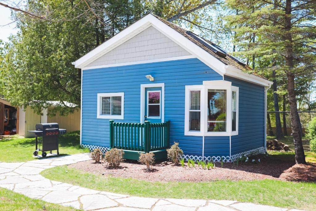 a blue tiny house in a yard at The Lighthouse Cottage Four in Wasaga Beach