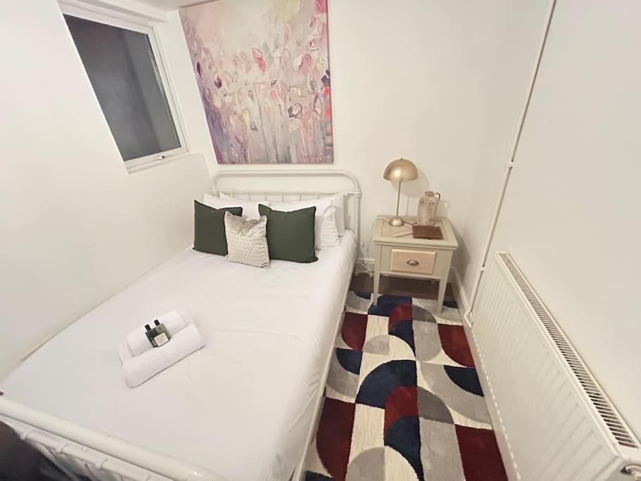een kleine slaapkamer met een wit bed en een raam bij Modern 2 bed apartment in Bristol city centre in Bristol