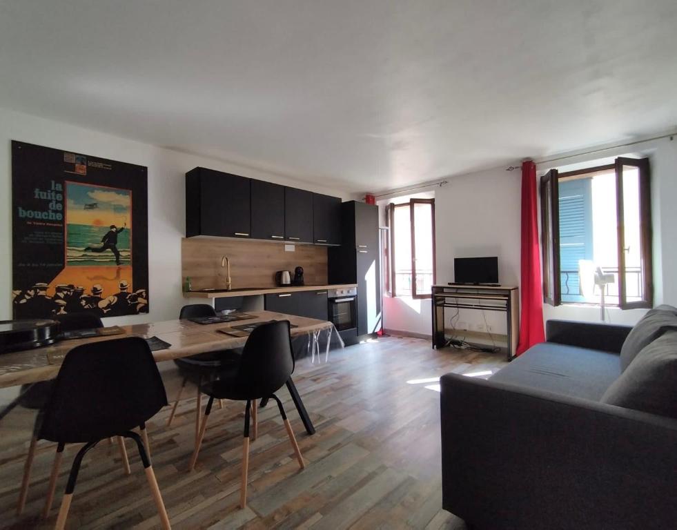 een woonkamer met een bank en een tafel en stoelen bij Sanary Paradise Port Climatisé in Sanary-sur-Mer