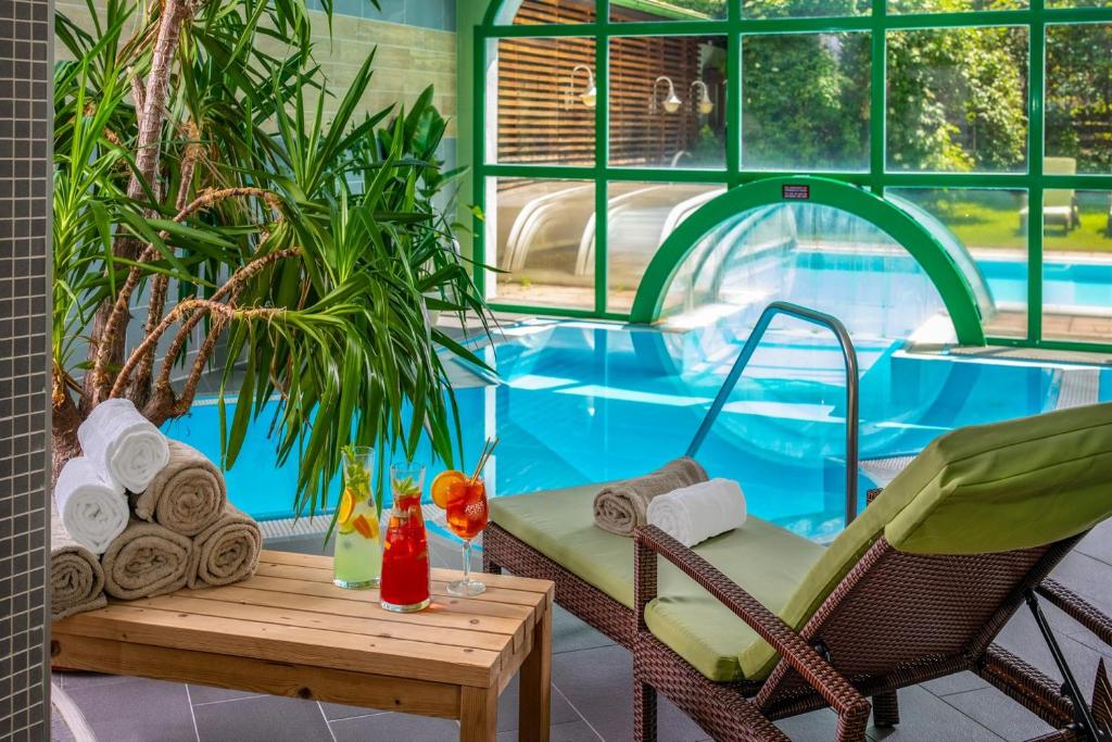 a patio with a table and chairs and a swimming pool at Hotel Alpenblick Kreischberg in Sankt Lorenzen ob Murau
