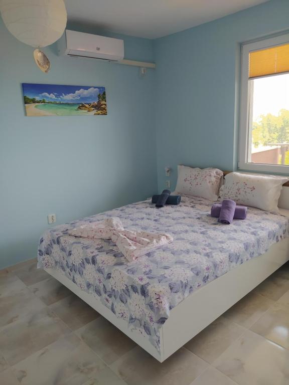 a bedroom with a bed in a room with a window at Апартамент White apartment град Китен in Kiten