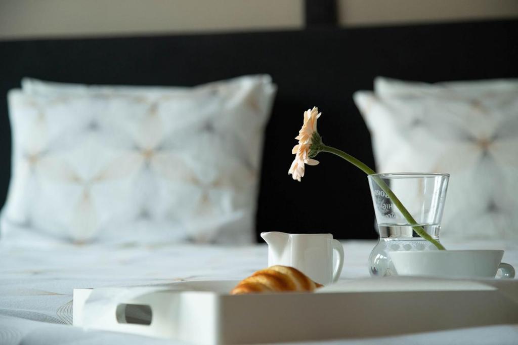 uma flor num vaso numa bandeja numa cama em Room "Carpe Diem" em Zele