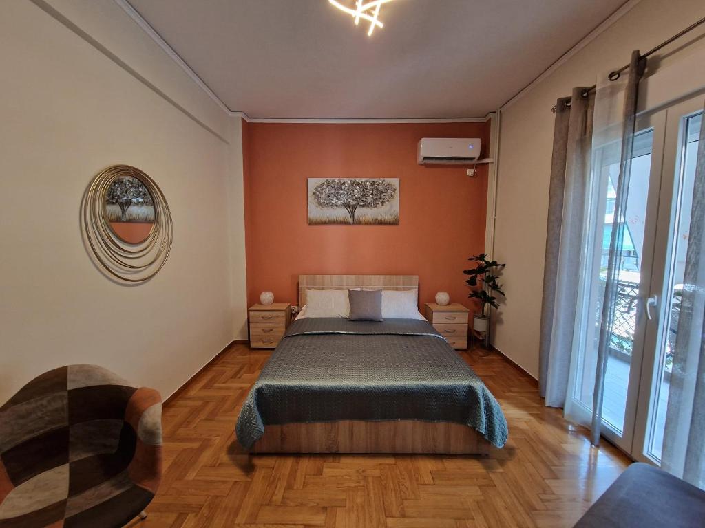 sypialnia z łóżkiem z pomarańczowymi ścianami i drewnianą podłogą w obiekcie Cozy Little Home w Atenach