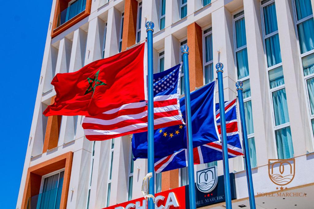 tres banderas volando delante de un edificio en Marchica Hotel, en Nador