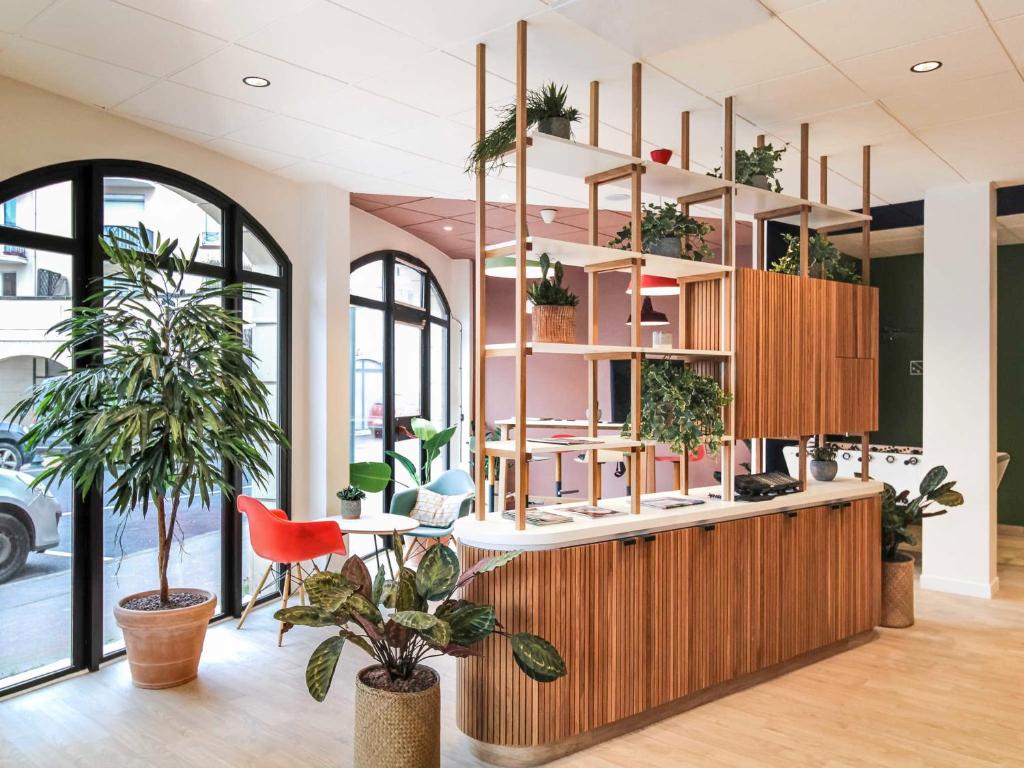a lobby with plants on the shelves at ibis Saint Gratien - Enghien-Les-Bains in Saint-Gratien