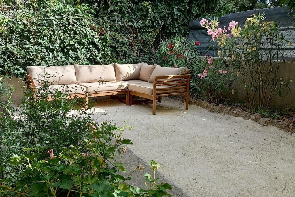 un sofá sentado en medio de un jardín en Grand appartement, 2 chambres et jardin, en Nimes