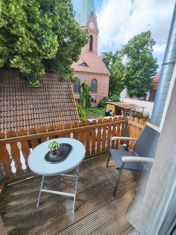 een terras met een tafel en twee stoelen en een kerk bij Ferienwohnung Monteurswohnung Großräschen in Großräschen