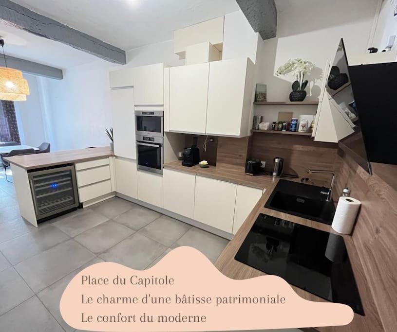 une cuisine avec des armoires blanches et un four à plaques de cuisson dans l'établissement Ô Toulouse, à Toulouse