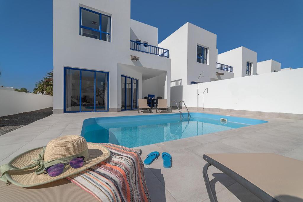 a villa with a swimming pool in front of a house at Villas Yaiza in Playa Blanca