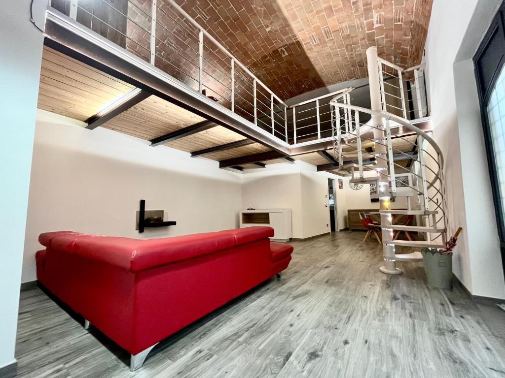 a living room with a red couch and a spiral staircase at Arno Loft in Florence