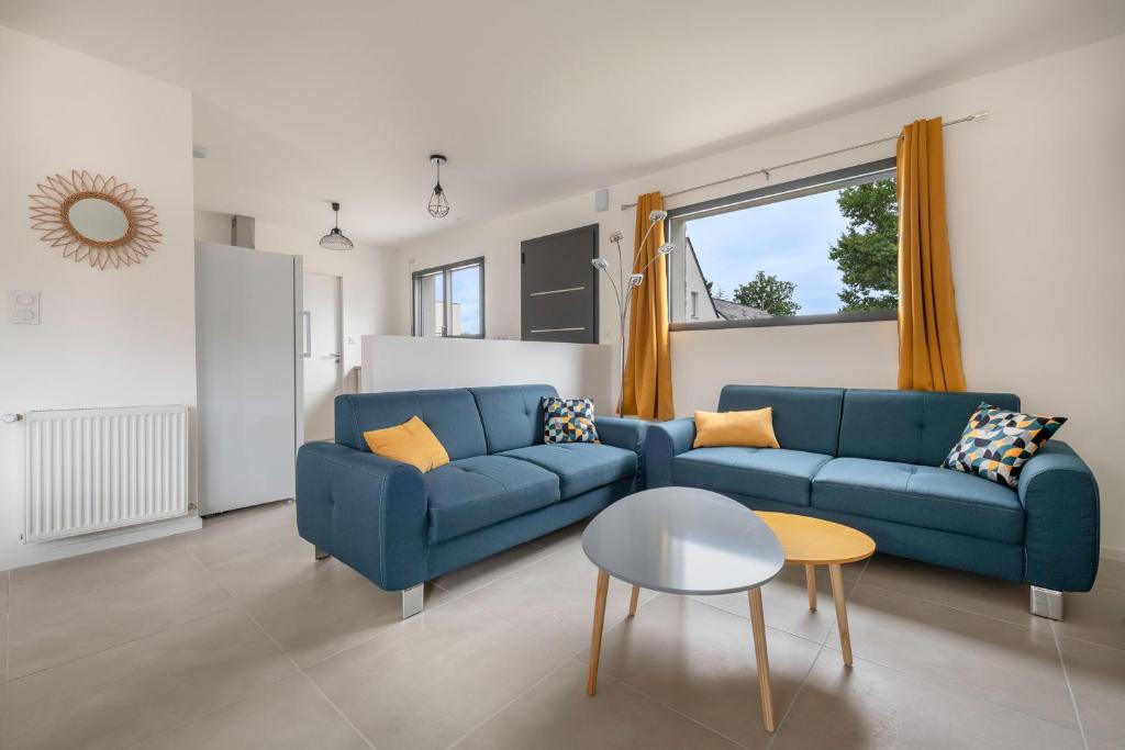ein Wohnzimmer mit einem blauen Sofa und einem Tisch in der Unterkunft Instants detente en famille au Tour-du Parc in Le Tour-du-Parc