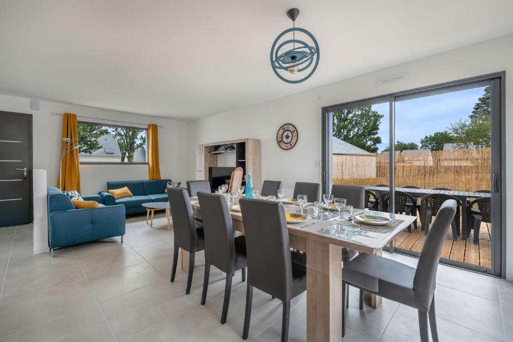 a dining room and living room with a table and chairs at Instants détente en famille au Tour-du Parc in Le Tour-du-Parc