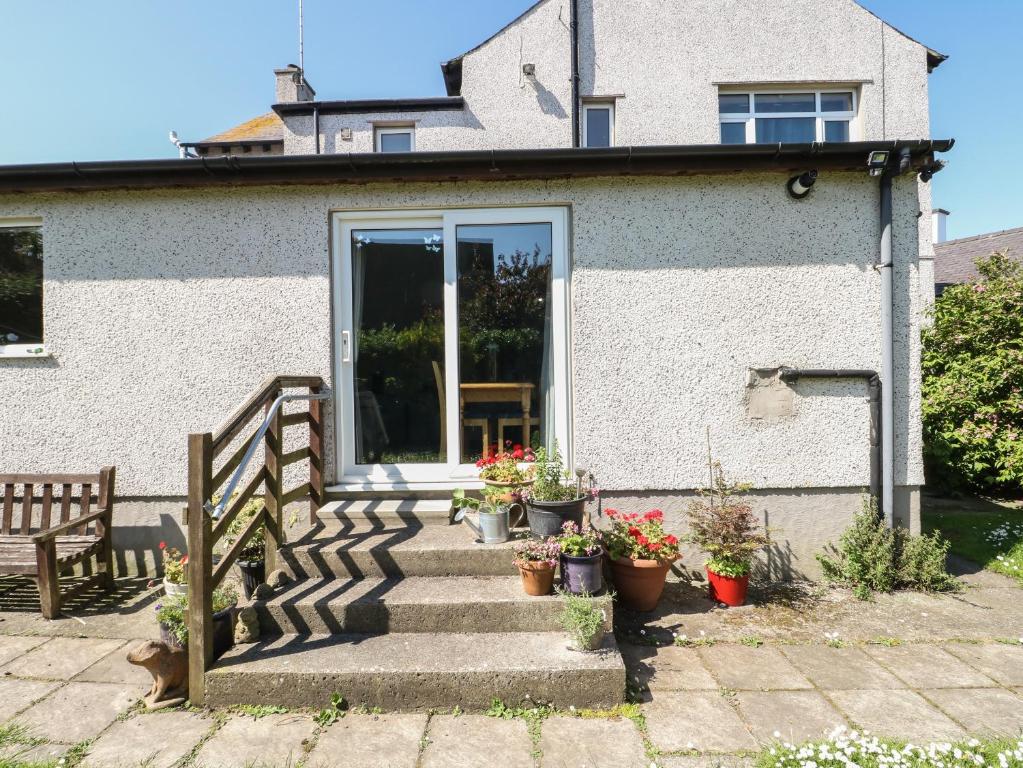 a house with stairs and potted plants on it at Finnisterre in Holyhead