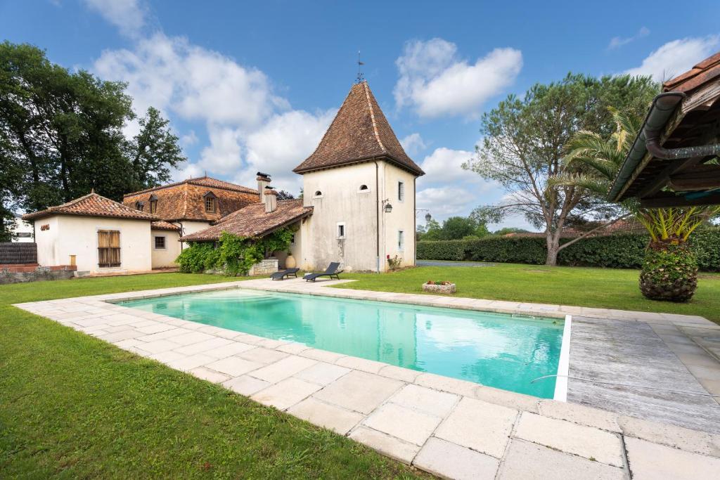 uma casa com piscina em frente a um edifício em Lou Grit - Maison pour 10 avec piscine privée em Salies-de-Béarn