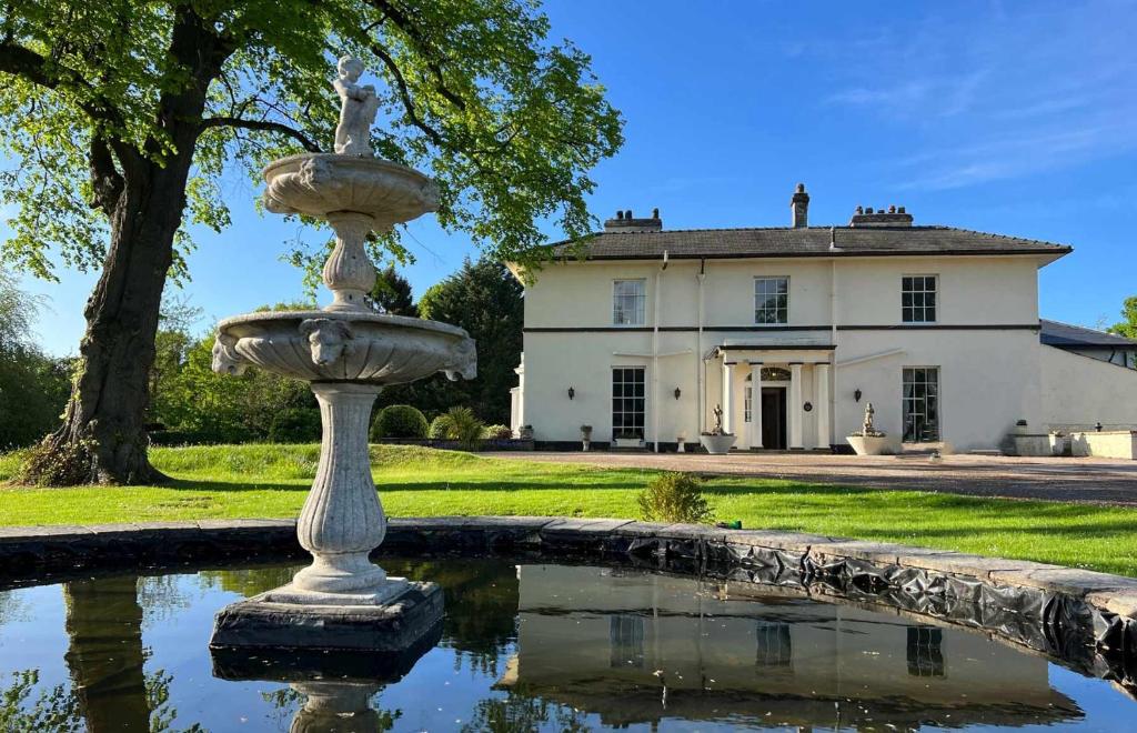 a water fountain in front of a house at Highfield Hall in Mold