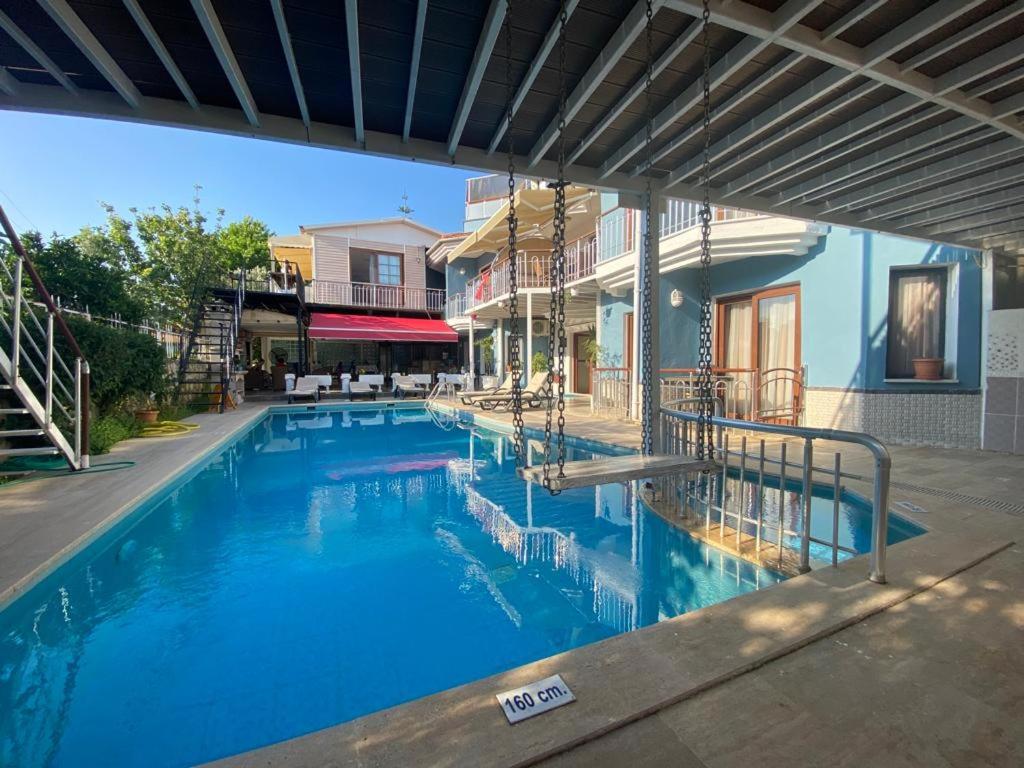 uma grande piscina azul numa casa em Tulip Apart Hotel em Ortaca