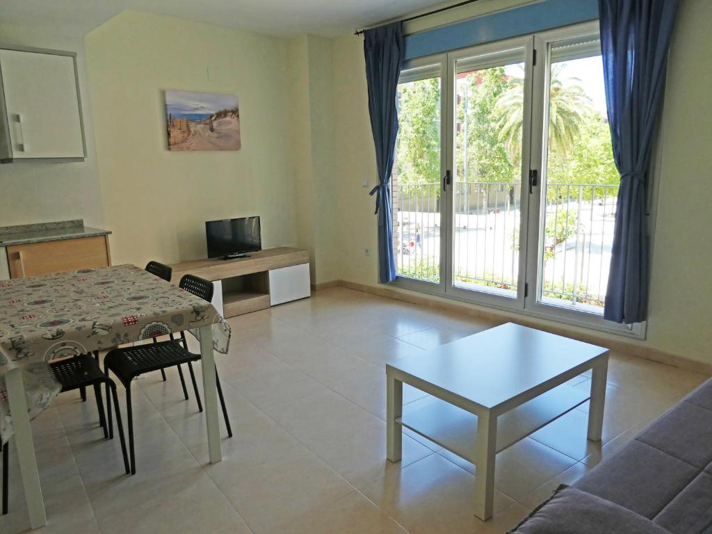 a living room with a table and a couch at Apartamentos Benicarló 3000 in Benicarló