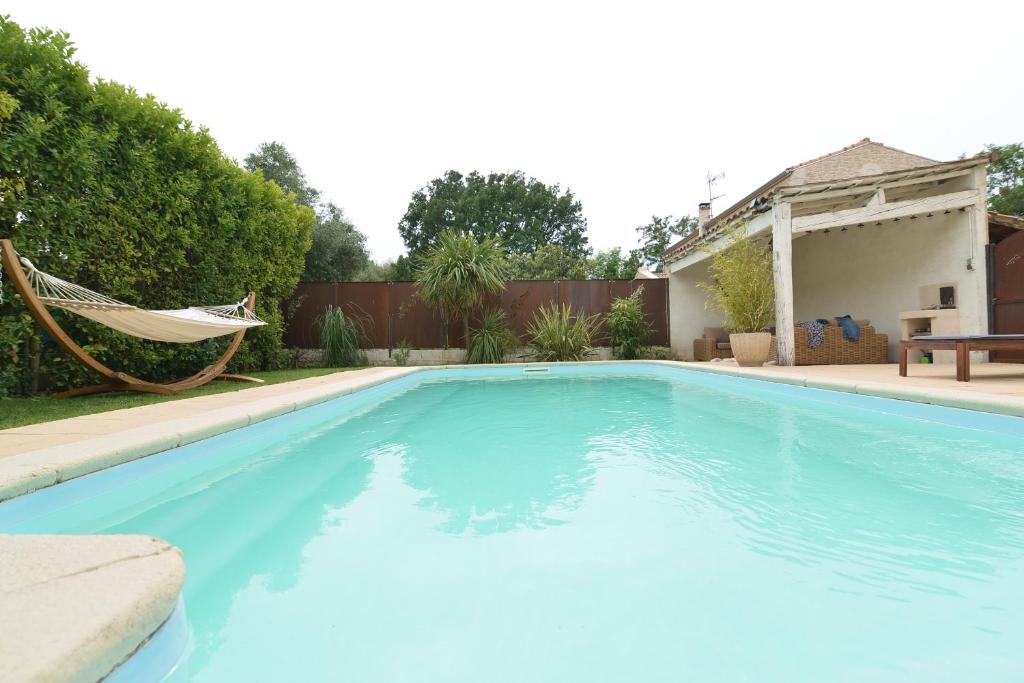 una gran piscina azul con una hamaca en un patio en La Lézarde, en Saint-Victor-la-Coste