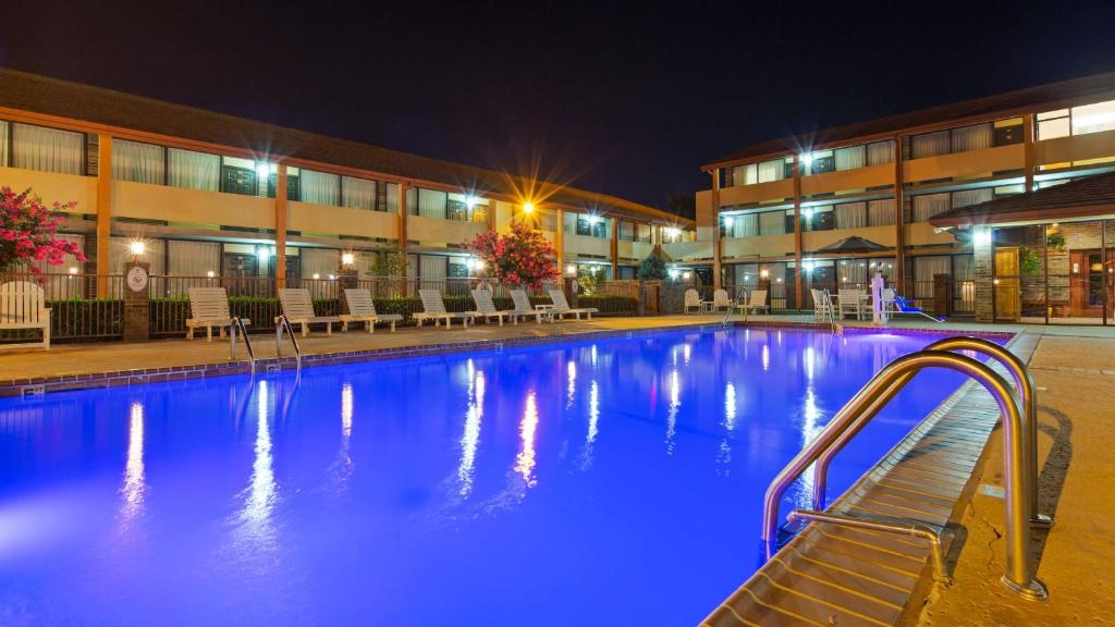 een zwembad voor een gebouw 's nachts bij Best Western Plus Saddleback Inn and Conference Center in Oklahoma City
