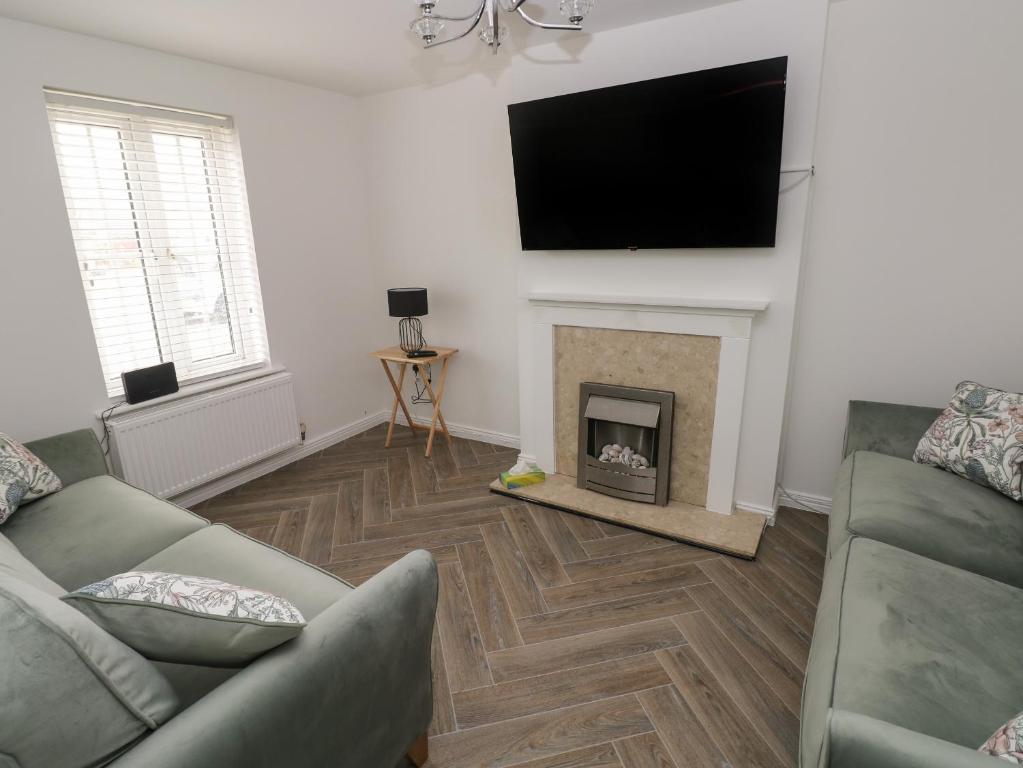 a living room with a fireplace and a flat screen tv at 39 Mariners Quay in Port Talbot