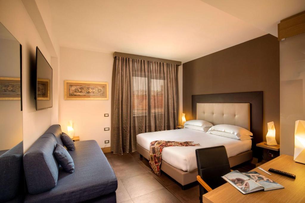 een hotelkamer met een bed en een bank bij Best Western Plus Hotel Spring House in Rome