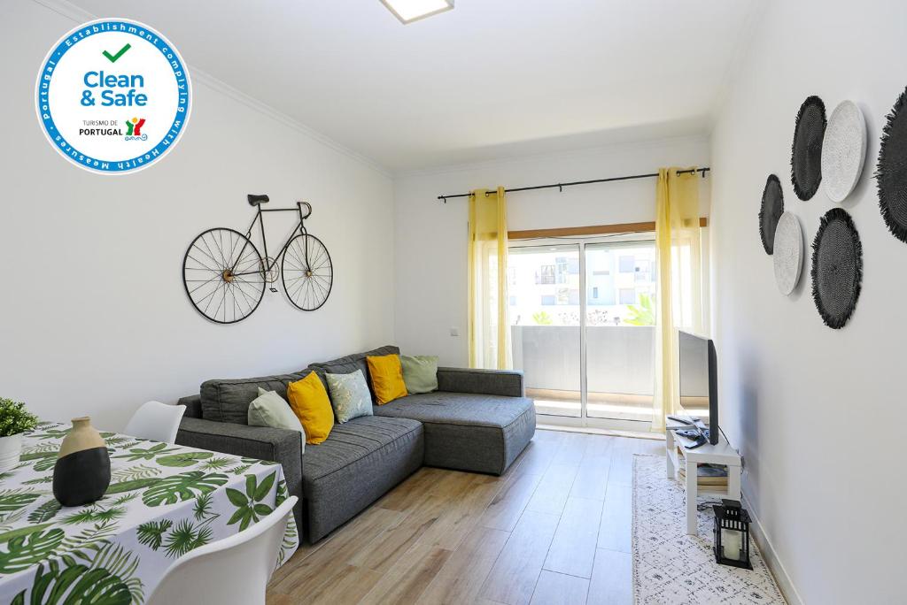 a living room with a couch and a bike on the wall at Beach Way Apartment in Lagos