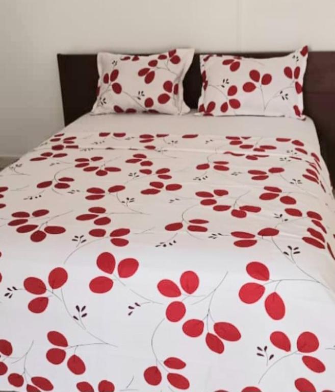 海岸角GreenSpring的白色棉被上带红色鲜花的床