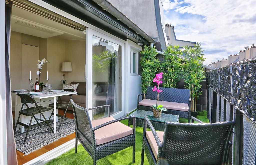 un patio avec des chaises et une table sur un balcon dans l'établissement St Michel - Deluxe Apartment - Harpe, à Paris