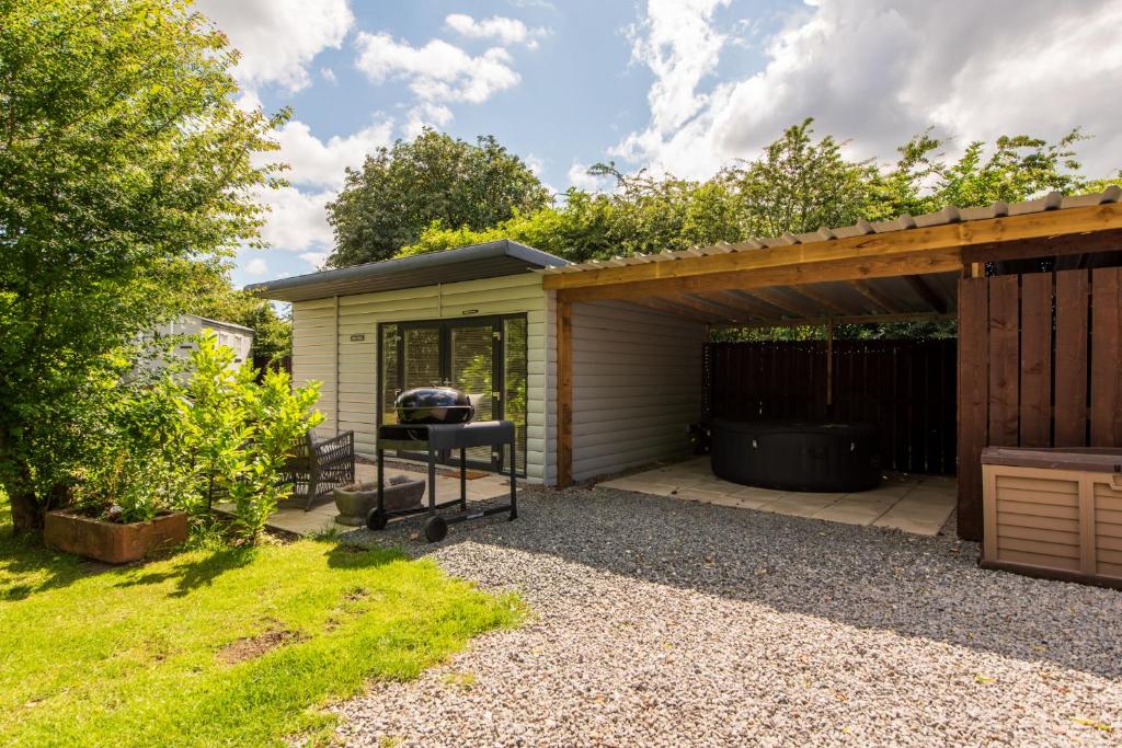 a backyard with a shed and a grill at Millie's Place in Durham