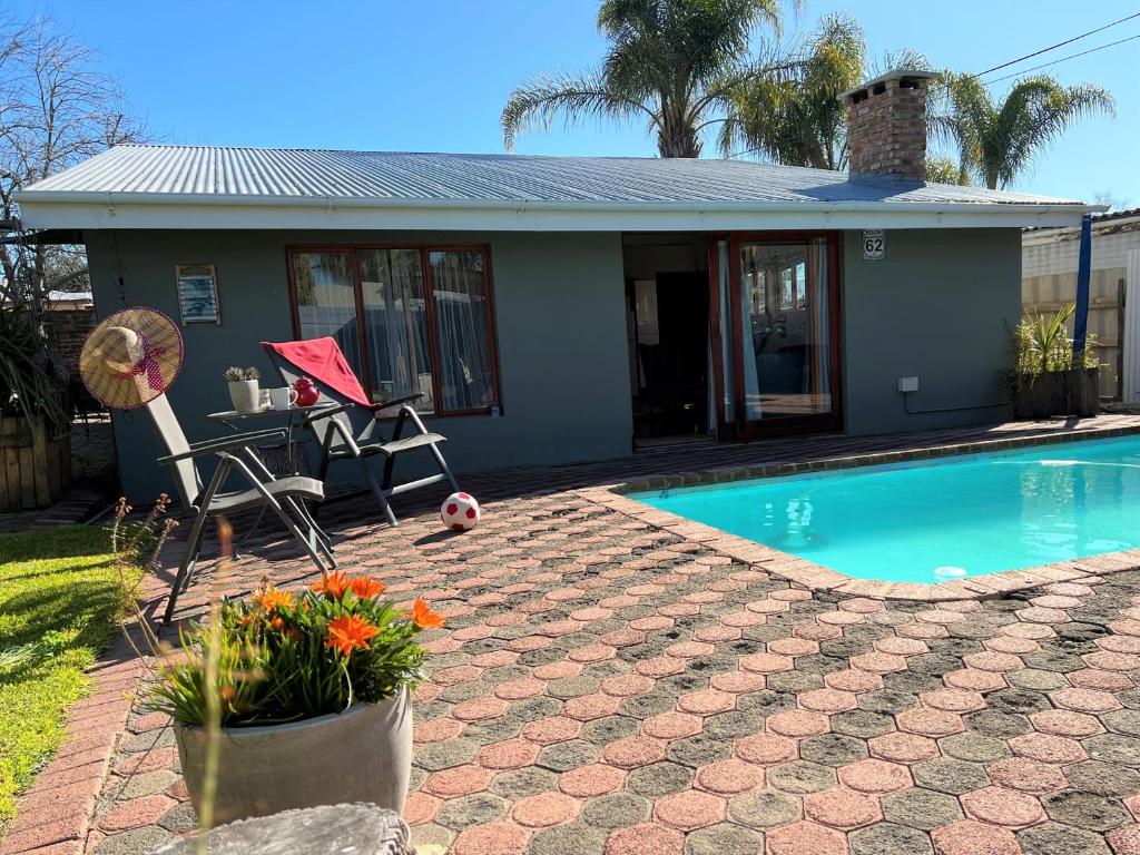 a house with a swimming pool in front of a house at Tuinhuis in Oudtshoorn