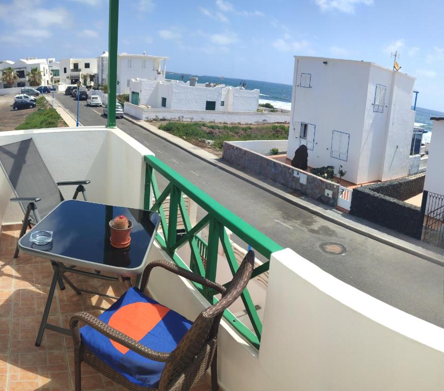 uma mesa e cadeiras numa varanda com vista para uma rua em Mar y Sol 7 with sea views em Punta Mujeres