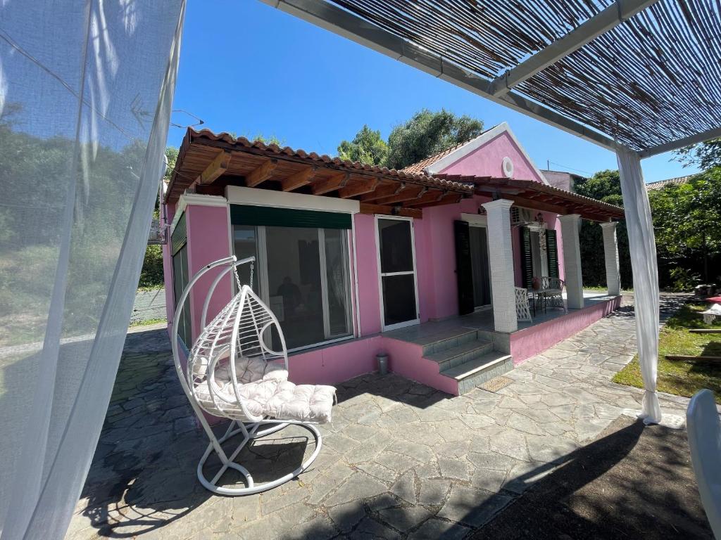 a pink house with a chair in front of it at Villa Penelope in Corfu Town
