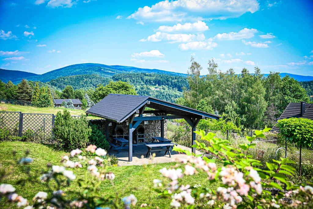 een picknickplaats in een tuin met bergen op de achtergrond bij Domek w górach - Prywatne Jacuzzi, Sauna, Grota Solna - PANORAMA CHEŁM SKI&SPA in Myślenice