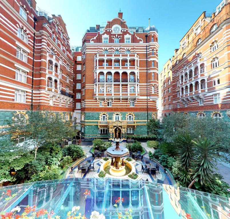 um edifício com uma fonte em frente a um edifício em St. James' Court, A Taj Hotel, London em Londres