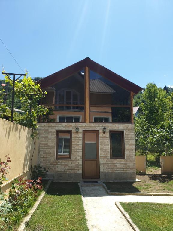 une petite maison en briques avec une porte marron dans l'établissement Red Roofs, à K'eda