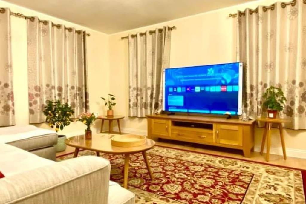 a living room with a large television and a couch at 2 Bedroom Flat in Ardwick Manchester in Manchester