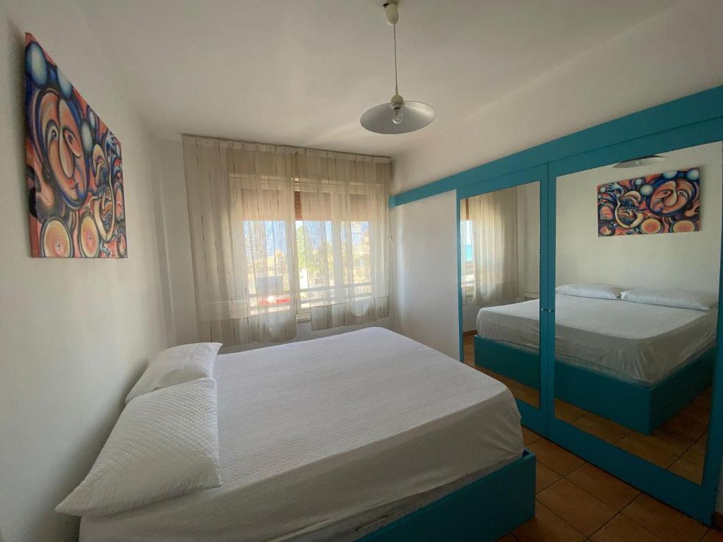 Un dormitorio con una cama grande y una ventana en TERRAZZA SUL MARE 2.0, en Marina di Modica