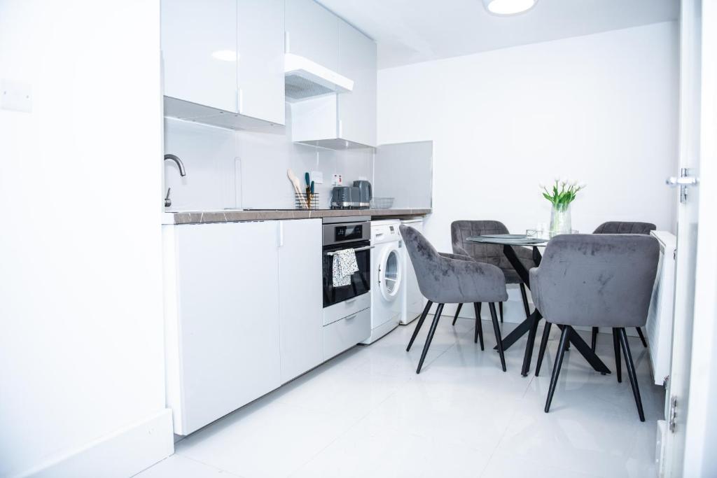 een keuken met een tafel en stoelen in een kamer bij 1B Apartment, 30 mins to Oxford Street in Londen