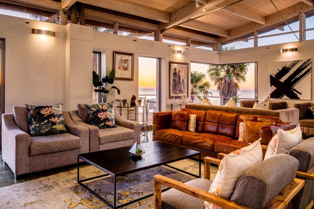 a living room with couches and a table at Lobster Villa in Cape Town
