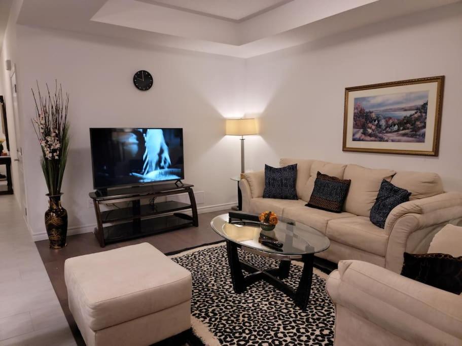 a living room with a couch and a tv at Deluxe 3 Bedroom near Hyde Park mall & Western Uni in London