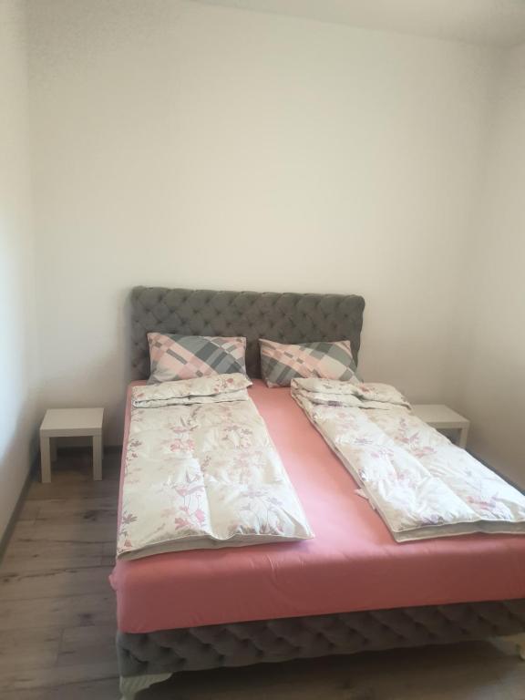 a bed in a room with two pillows on it at Apartmani Banja Vrujci Lux in Gornja Toplica